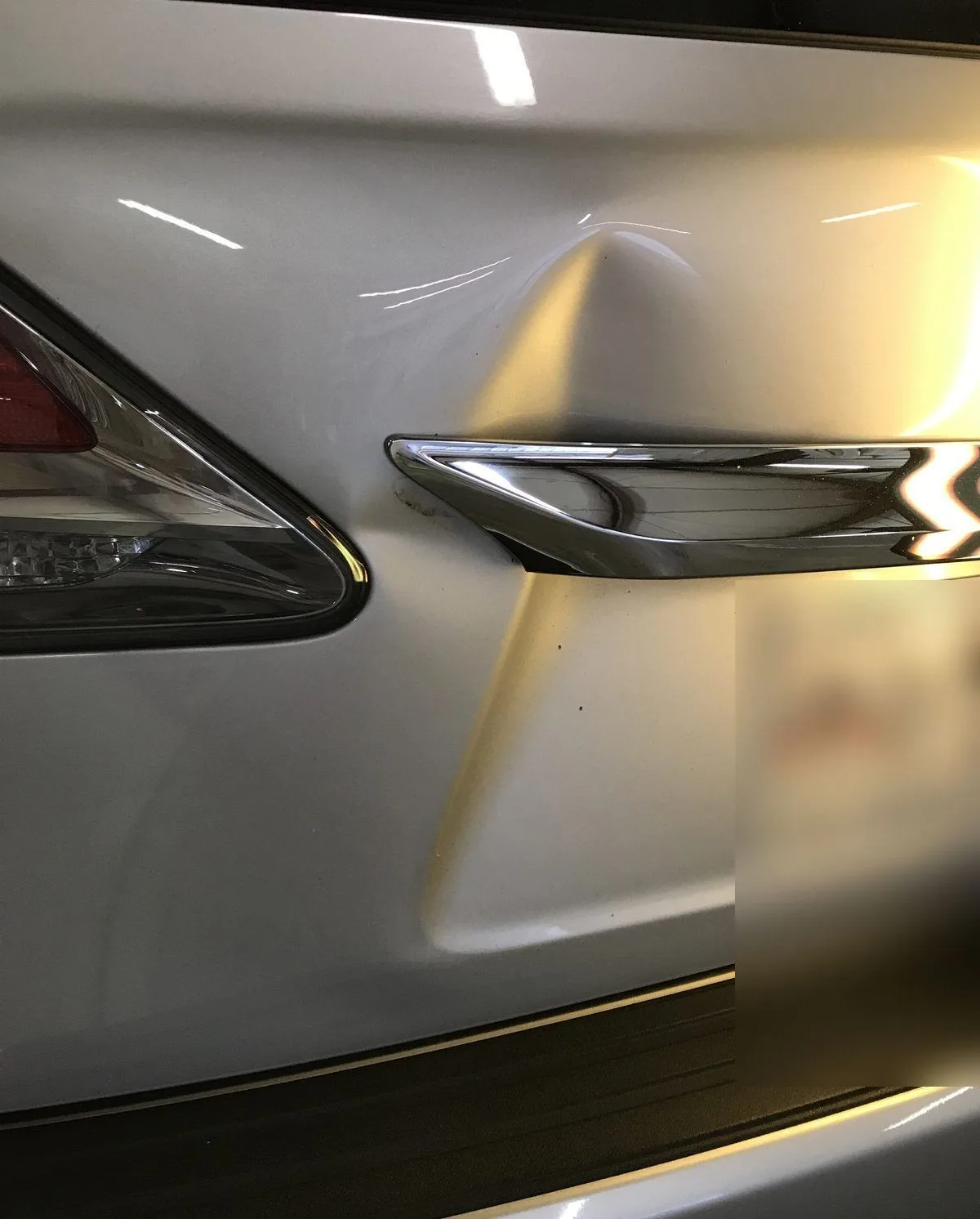 Localized dent on a Lexus RX rear hatch viewed under reflection lighting before PDR