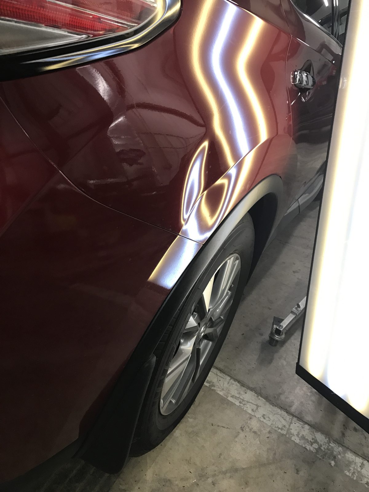 Dent damage on a Nissan Murano rear quarter panel before paintless dent repair